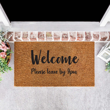 personalised natural coir door mat, written as 'Welcome please leave by 9PM' in black