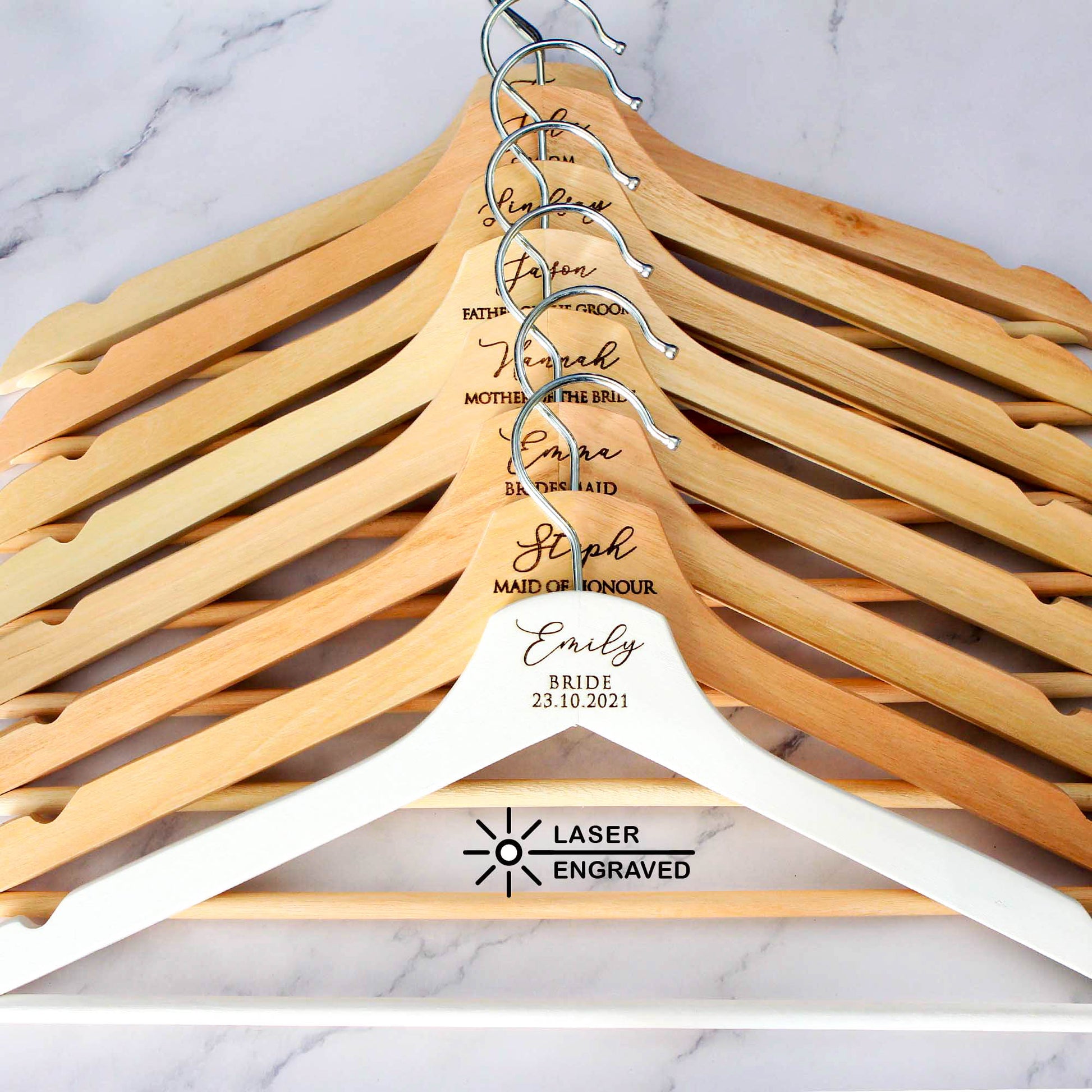 personalised hangers in white and natural wooden colour. The hangers are laser engraved the name, title and date of the wedding